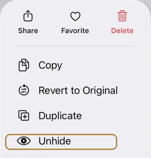 iOS 26 quick-action menu inside the Hidden album, with Unhide highlighted lower in the menu